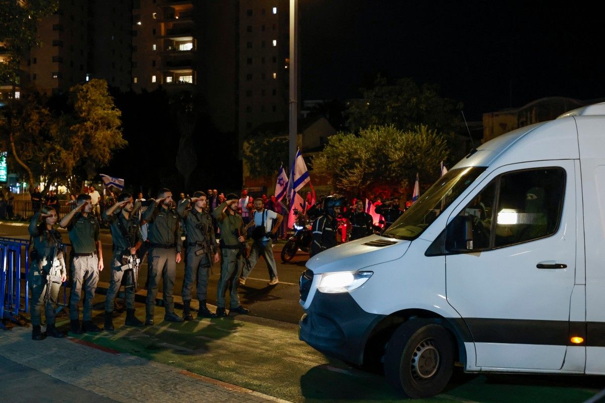 جنود إسرائيليون يؤدون التحية العسكرية عند وصول مركبات تنقل جثث أسرى تم تسليمهم في أعقاب صفقة التبادل (أ ف ب)